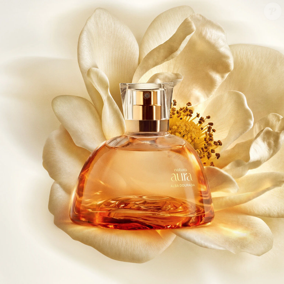 O Aura Alba Dourada, da Natura, é um Deo Parfum que combina a Rosa Alba e a Flor do Mel com notas suculentas de lichia. A composição ganha profundidade com o calor ambarado do cumaru e da priprioca, criando uma proposta floral que também explora nuances quentes