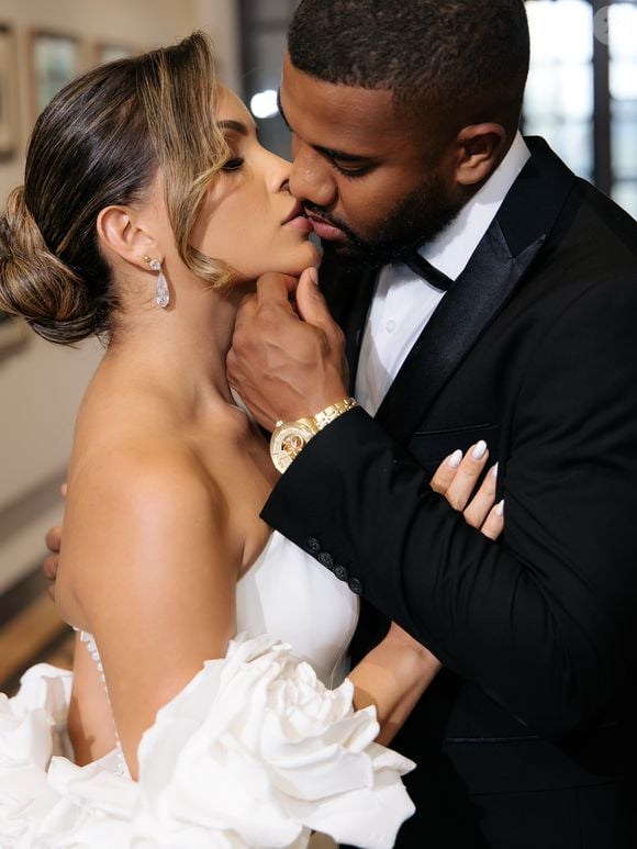 Enquanto Emilly Araújo escolheu um vestido marcado por flores e volume, Davi Brito seguiu uma proposta clássica com um smoking preto sob medida e lapela cintilante