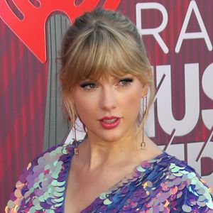 Taylor Swift arrasa no I Heart Radio com macaquinho metalizado e sandália com delalhe de borboleta