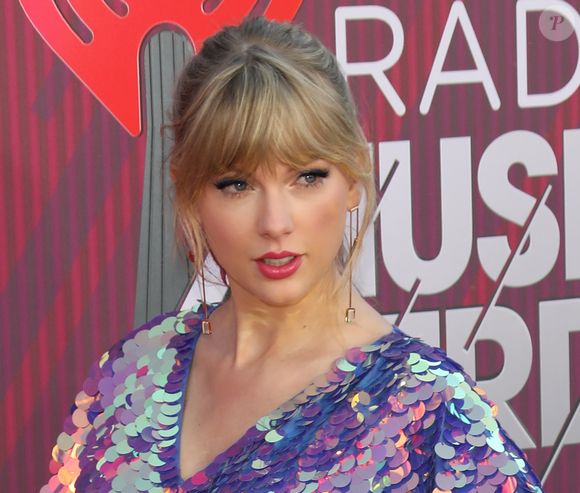 Taylor Swift arrasa no I Heart Radio com macaquinho metalizado e sandália com delalhe de borboleta