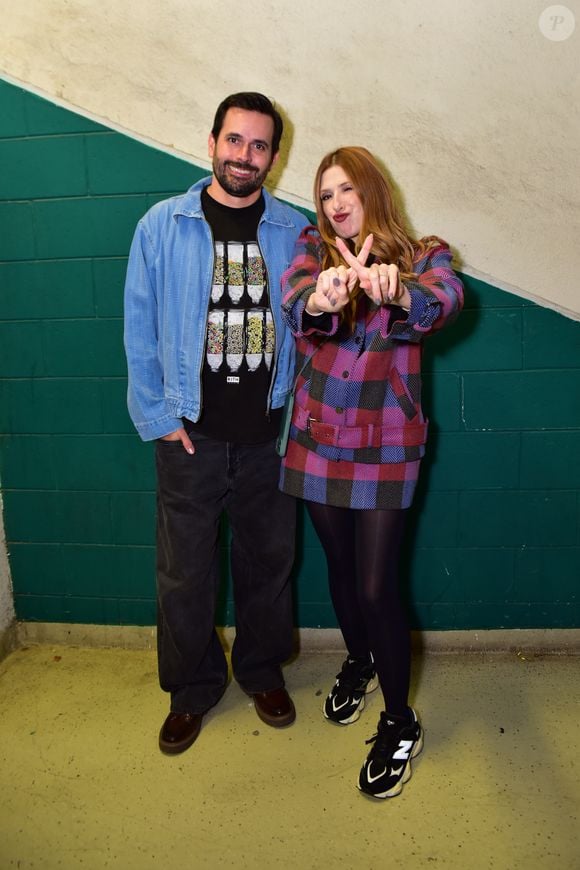Ao lado do marido, Dani Calabresa usou um trench coat xadrez e brincou com o X de Xuxa ao posar para fotos