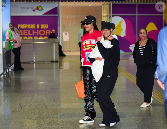 Brunna Gonçalves sorriu no desembarque com a filha, Zuri, e a mulher, Ludmilla