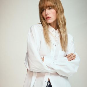 A Camisa de Popelina com Bolso da Zara é confeccionada em fiação de algodão 100% e tem gola com lapela, mangas amplas com punhos e bolso de patch frontal