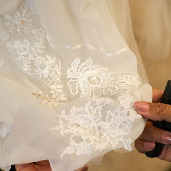 A saia, construída em patchwork, é um verdadeiro relicário: feita com rendas, fios, fitas, pérolas, crochês e botões de madeira que remetem aos vitrais da capela, ela representa as camadas da vida e da espiritualidade de Ana.