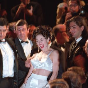 Madonna surpreendeu ao remover um robe rosa no tapete vermelho, revelando um conjunto de sutiã cônico e cinta-liga