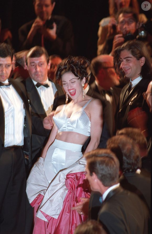 Madonna surpreendeu ao remover um robe rosa no tapete vermelho, revelando um conjunto de sutiã cônico e cinta-liga