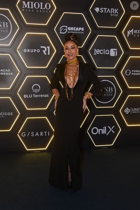 Sabrina Sato apostou em joias maximalistas douradas e vestido preto com decote poderoso para o mesmo leilão