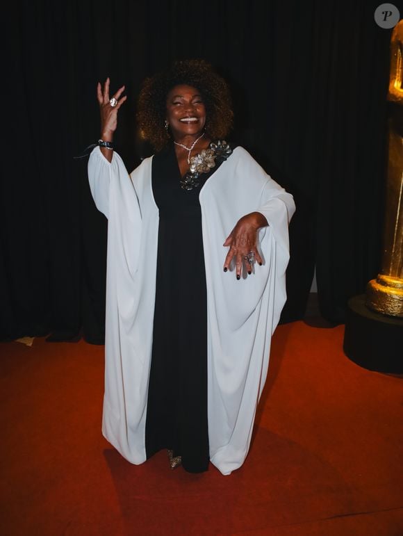 Zezé Motta apostou em um vestido longo preto e branco, com mangas longas e aplicações de flores metalizadas no ombro. Joias chamativas e sapatos brilhantes completaram o look