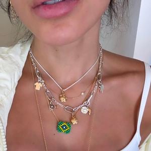 Com regata branca adornada por uma bandeira do Brasil em strass, maxi colares inspirados no futebol e jorts clara, Anitta apostou em uma produção descontraída que já está chamando atenção dos fãs.