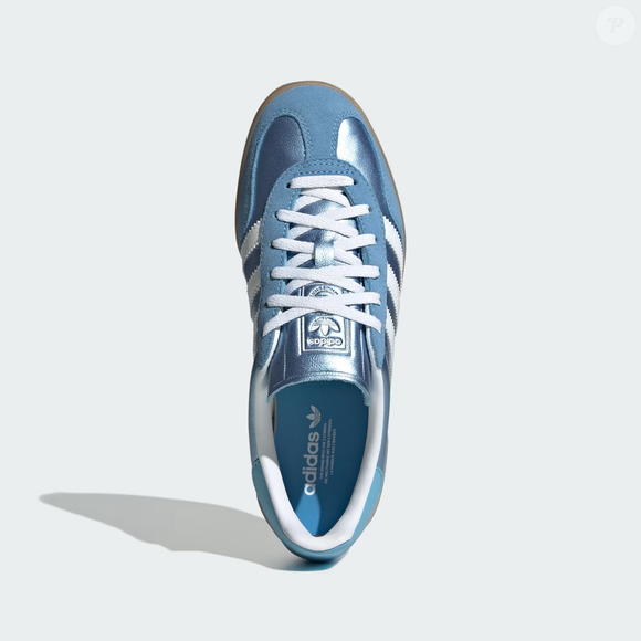 Inspirado na estética Frutiger Aero que marcou os anos 2000, o Adidas Gazelle Indoor Aquamarine aposta no couro metálico brilhante para transformar qualquer produção básica