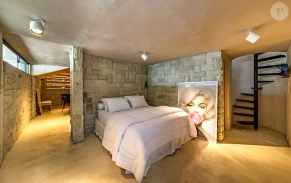 O terceiro quarto da propriedade conta com decoração rústica e ambiente fechado