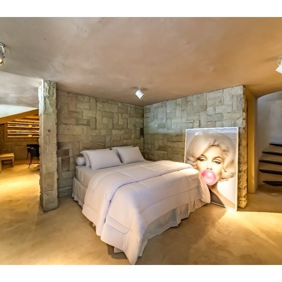 O terceiro quarto da propriedade conta com decoração rústica e ambiente fechado