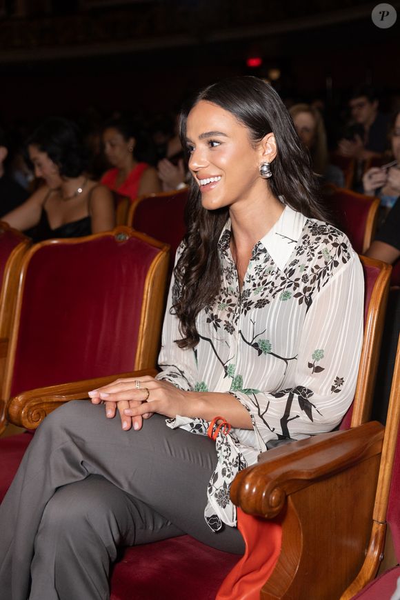A camisa com estampa de flores de Victoria Beckham usada por Bruna Marquezine está por R$ R$2.926,95. A calça cinza de modelo alfaiataria, elegante, custando R$ R$6.972,00.