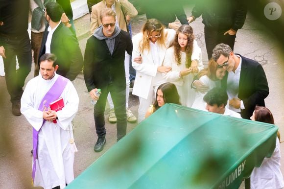 Schynaider Moura foi consolada pelas filhas enquanto acompanhava o cortejo para o sepultamento de Anne-Marie