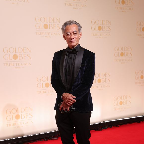 Chico Diaz escolheu um smoking com blazer de veludo azul-marinho, cujas lapelas em cetim preto criam um jogo de luz elegante sob os flashes. Fugindo da camisa branca óbvia, ele optou por uma camisa social preta inteiramente fechada, acompanhada de uma gravata borboleta de seda no mesmo tom