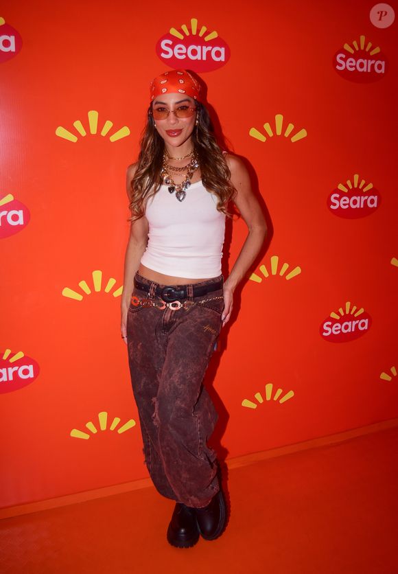 Campeã do 'BBB', Renata Saldanha escolheu uma produção despojada com regata branca, calça jeans marrom, botas pretas, lenço na cabeça e muitos colares