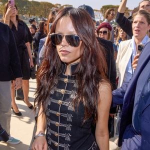 A atriz Jenna Ortega no desfile da Christian Dior, eterna 'Wandinha', ajudou a impulsionar a febre das jaquetas napoleônicas após aparecer com produções sombrias e estruturadas que lembram o visual militar glam que domina 2026