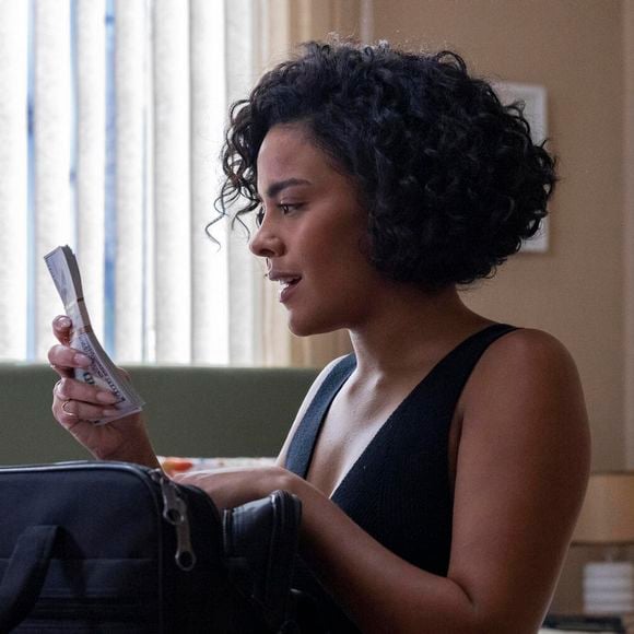 Maria de Fátima (Bella Campos) pega os dólares e vai comemorar com César (Cauã Reymond) na novela 'Vale Tudo'