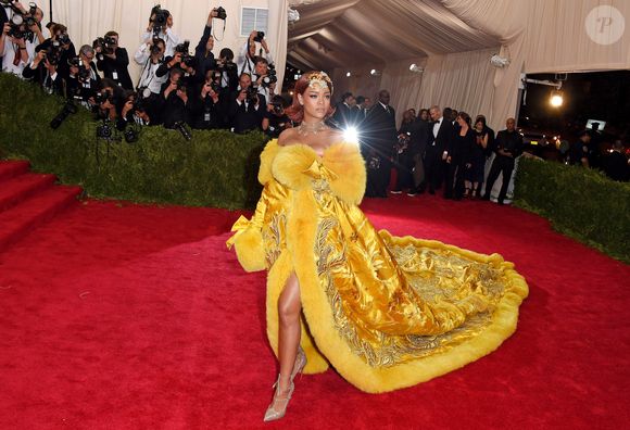 Rihanna no Met Gala 2015 com vestido amarelo de Guo Pei, com cauda gigante e bordados dourados