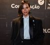 Bruna Marquezine chamou atenção ao investir em um look de alfaiataria com referências diretas ao smoking 'masculino'. A atriz apostou em um terno preto de corte preciso, com blazer de lapelas acetinadas e camisa branca de gola alta, dispensando gravata e reforçando a estética minimalista e sofisticada
