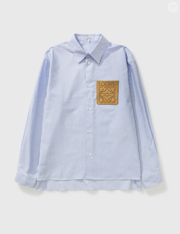 Com modelagem ampla e proposta fashionista, a camisa listrada da Loewe escolhida por Bruna Marquezine custa aproximadamente R$ 10.816 e virou destaque entre os fãs da atriz