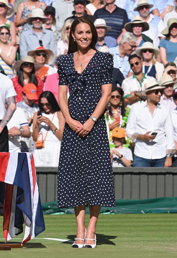 Kate Middleton usou um vestido longo azul-marinho de bolinhas brancas da estilista Alessandra Rich, com gola estilo marinheiro e laço frontal