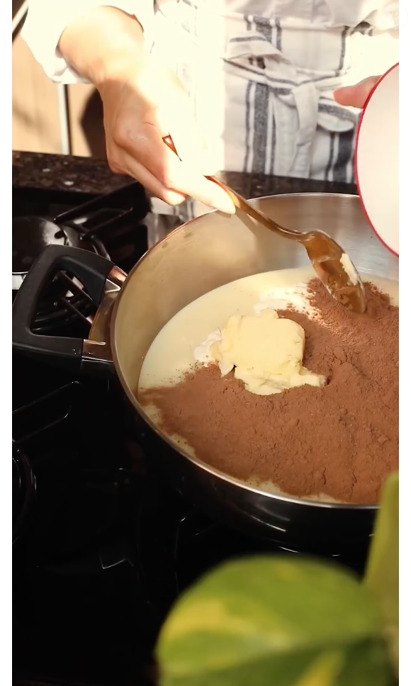 Para preparar a calda do bolo de cenoura, acrescente os ingredientes a uma panela e mexa sem parar