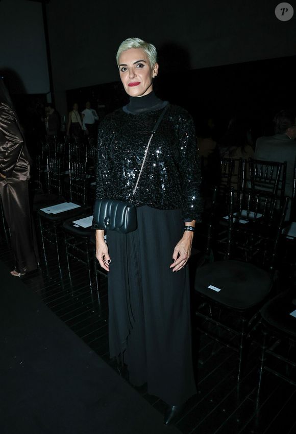 Fabiola Kassin: a produção noturna All Black traz um blusão de paetês pretos com mangas 3/4 sobreposto a uma blusa de gola alta. A composição conta com uma saia longa plissada de caimento fluido e uma bolsa tiracolo preta acolchoada com alça de corrente fina