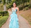 Flávia Viana apostou em um look sofisticado para o casamento, com um vestido longo em tom azul turquesa que transmite frescor e leveza. A peça tem o busto todo bordado em pedrarias reluzentes que formam o desenho de uma borboleta, enquanto as laterais vazadas realçam a silhueta. A saia, confeccionada em camadas fluidas de organza, cria um efeito esvoaçante e volumoso, conferindo movimento a cada passo