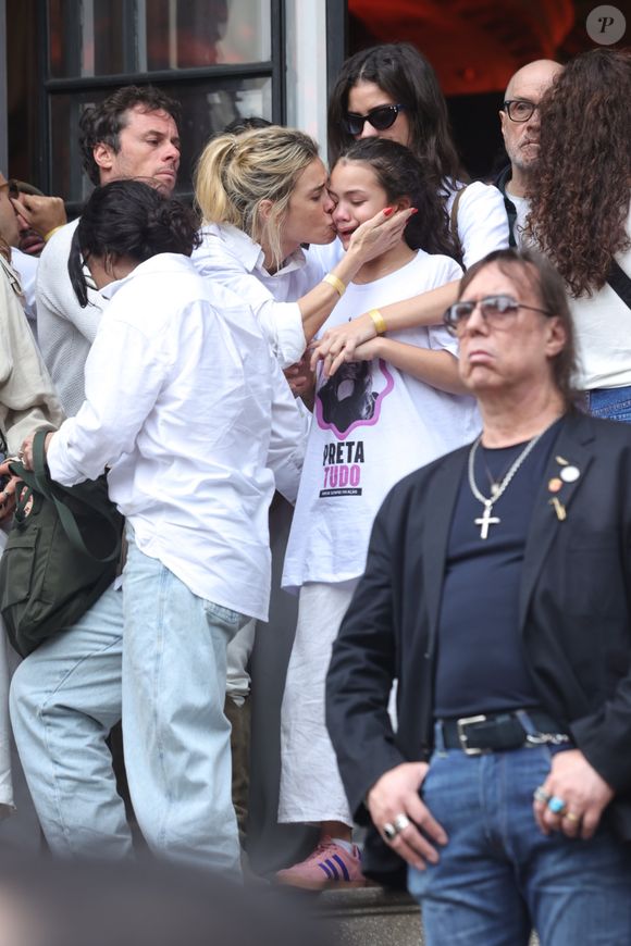 Carolina Dieckmmann dá um beijo no rosto de Sol de Maria, única neta de Preta Gil, após velório da cantora