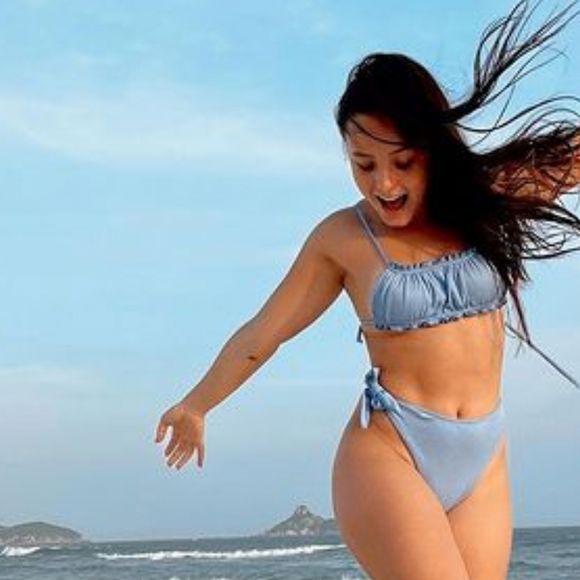 Larissa Manoela gosta de ousar no modelo de biquíni cortininha, como esse em cor clara com top de amarrações diferentes.