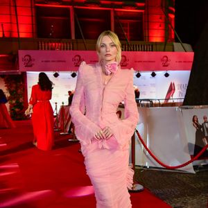 Caroline Trentini: exalando o conceito high fashion, a top model utilizou uma criação monocromática em rosa pastel. O conjunto é marcado por camadas de tule drapeado e babados verticais que conferem uma textura densa e fluidez ao caminhar. O detalhe de destaque é a aplicação de uma flor gigante (corsage) no pescoço, tendência absoluta das passarelas internacionais. O blazer cropped com ombros estruturados equilibra a delicadeza da saia longa de sereia
