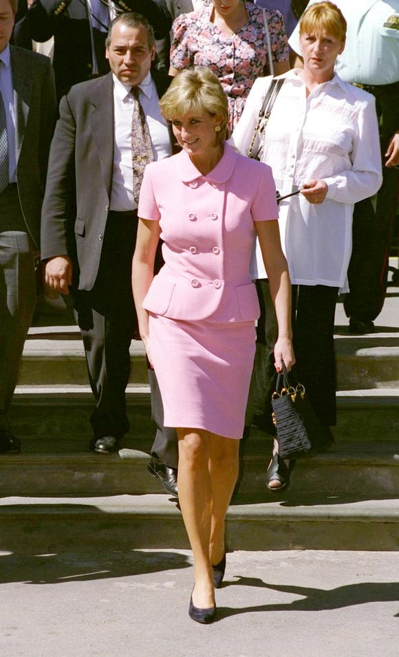 Princesa Diana adorava apostar nos conjuntos clássicos compostos de saia ou calça na cor rosa, transmitindo elegância e autoridade.