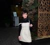 A base do look começa com uma blusa de gola alta preta justa, que serve como canvas neutro para o protagonismo do vestido. Por cima, Klara brilhou (literalmente) com um vestido de tweed off-white estilo baby doll