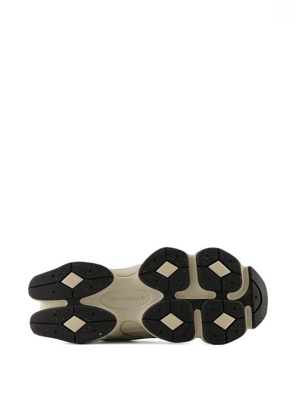Com preço de R$ 1.711, o New Balance 9060 com patch de logo aparece em uma combinação de shipyard linen e bege, com mesh de nylon, camurça e amortecimento ABZORB