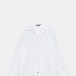 A Camisa Básica Oxford da Zara é confeccionada em fio de algodão e apresenta gola de lapela, decote V, mangas amplas e punhos com botões