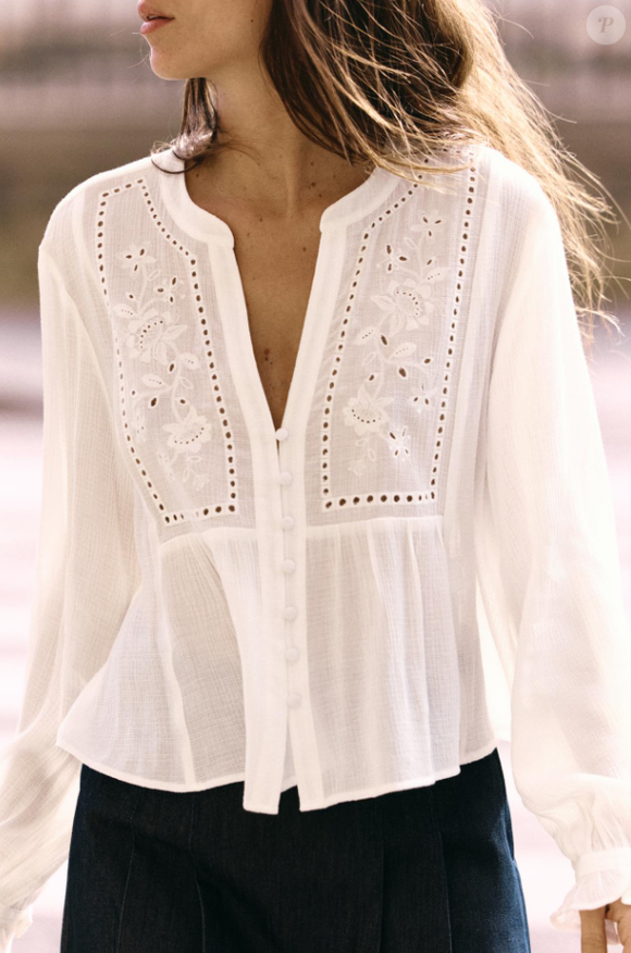 Camisa disponível na loja virtual da Zara traz gola redonda e decote V. As mangas amplas trazem bordados combinando.