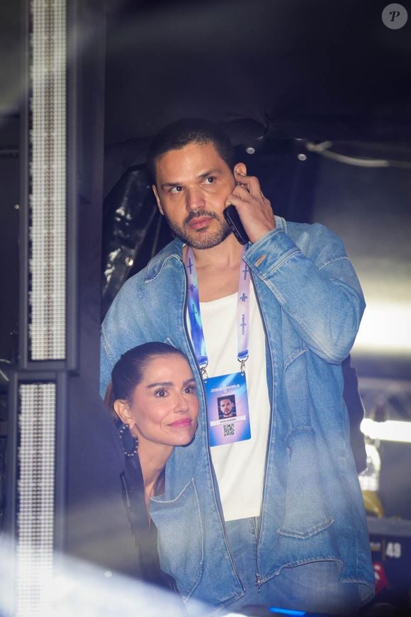 Sorridente, Deborah Secco foi vista ao lado do galã enquanto ele falava no telefone