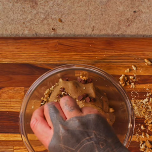 Massa da torta cookie ganha textura ao ser misturada com gotas de chocolate e pedaços de nozes ou macadâmia