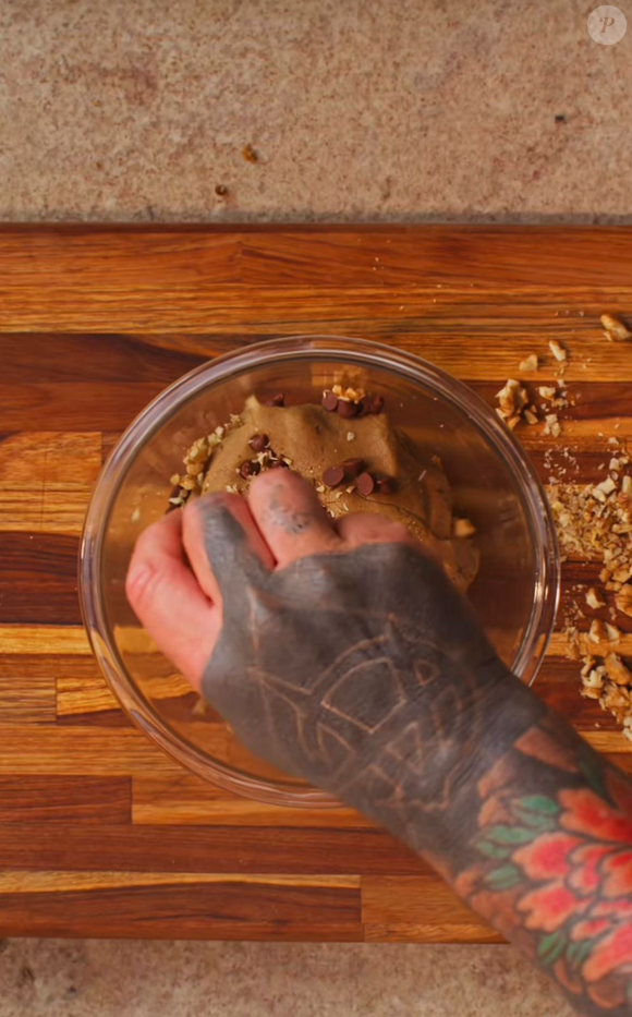 Massa da torta cookie ganha textura ao ser misturada com gotas de chocolate e pedaços de nozes ou macadâmia