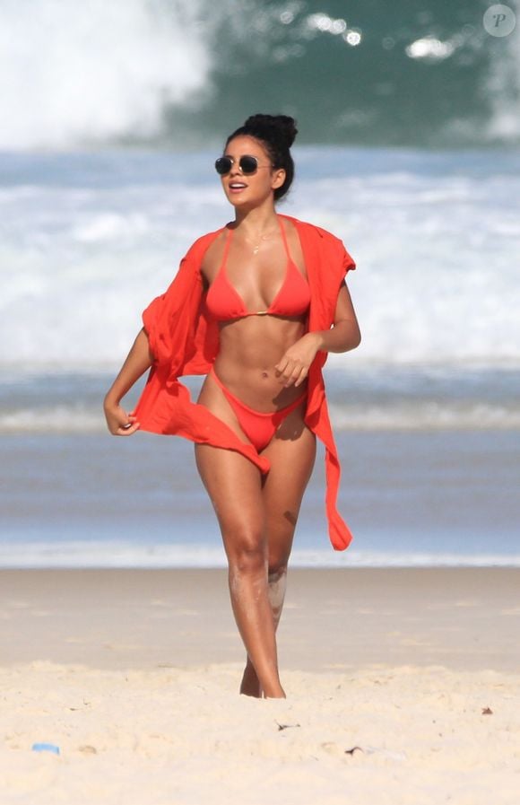 Em dia de praia no RJ, Bella Campos usou biquíni laranja e um óculos de sol para compor o look