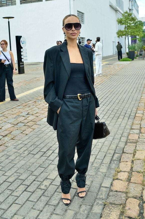 A influenciadora Júlia Rodrigues aliou o blazer com uma camiseta simples - e destaque para as sandálias amarradas sobre a calça!