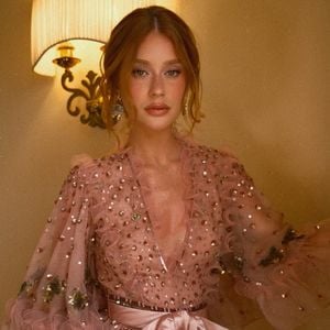 Com um acentuado decote em V o vestido de Marina Ruy Barbosa traz o romantismo do tule rosa no decote