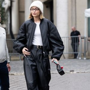 Durante a Semana de Moda de Paris, a modelo Gigi Hadid apareceu usando um par de sapatilhas da marca Mansur Gavriel antes de desfilar para a Miu Miu. O look combinava jaqueta bomber ampla com calça de couro, criando um visual moderno e despretensioso.
