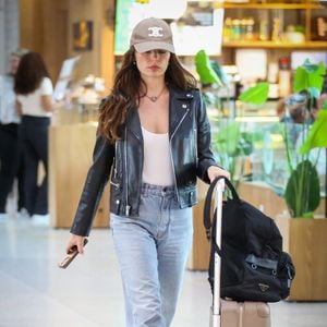 Outro item que chamou atenção foi a bagagem de mão da atriz. Sobre a mala, foi possível identificar uma it bag da Prada