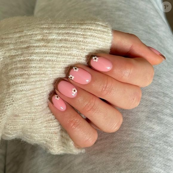 Unhas quadradas com florzinhas e francesa nunca saem de moda, misturando dois clássicos que passam um ar mais rejuvenescido.