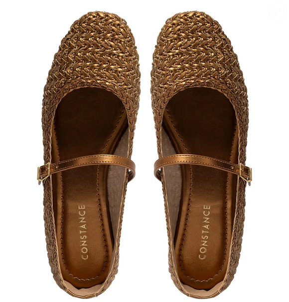 A sapatilha feminina de tressê na cor bronze, da Constance Calçados, traz bico mais quadrado e fechamento em fivela.