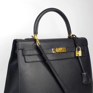 Hermès Kelly preta é simples, com alça curta e comprida, além de um cadeado de acessório