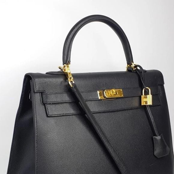 Hermès Kelly preta é simples, com alça curta e comprida, além de um cadeado de acessório