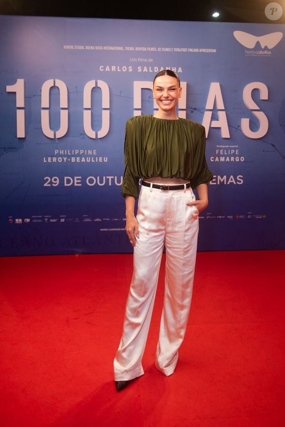 Isis Valverde usou uma blusa cropped verde-oliva de mangas volumosas com calça branca de alfaiataria e scarpins pretos